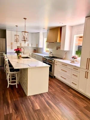 Modern kitchen with white cabinetry, quartz counters, and wood flooring