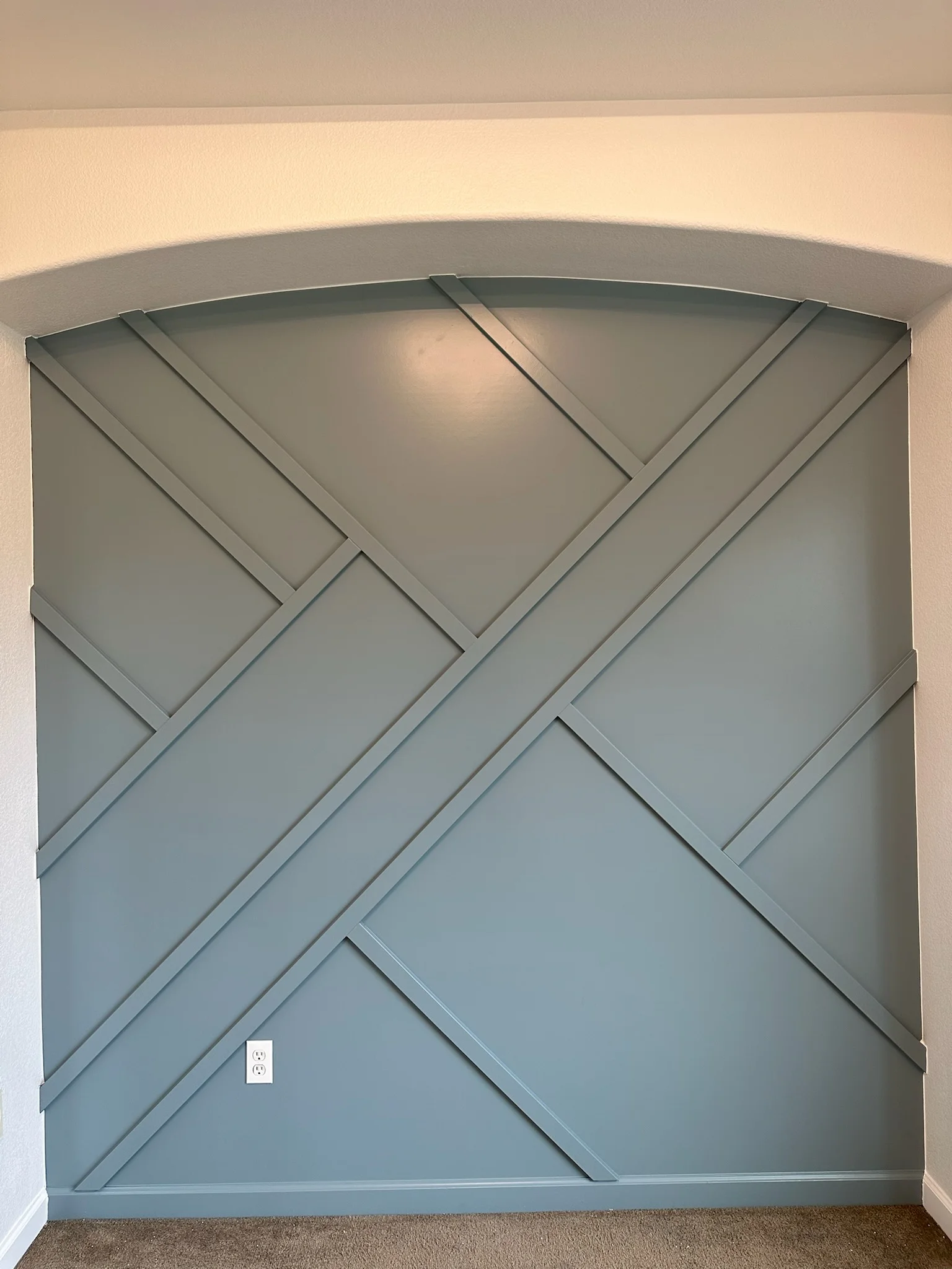 Gray shiplap wall with diagonal chevron pattern and curved soffit detail